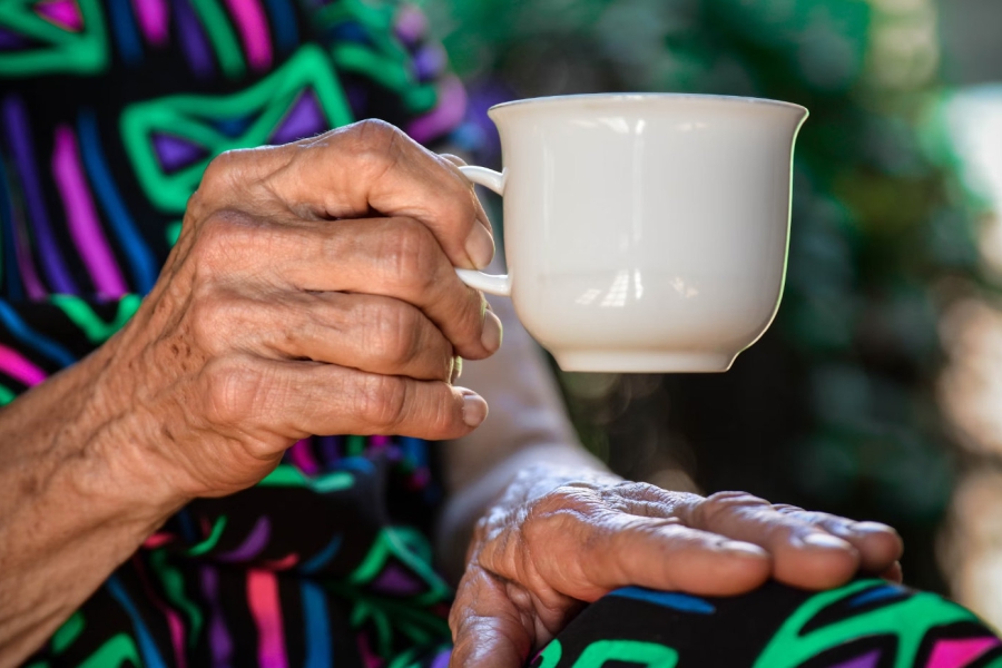 Photo of older hands holding a tea cup.