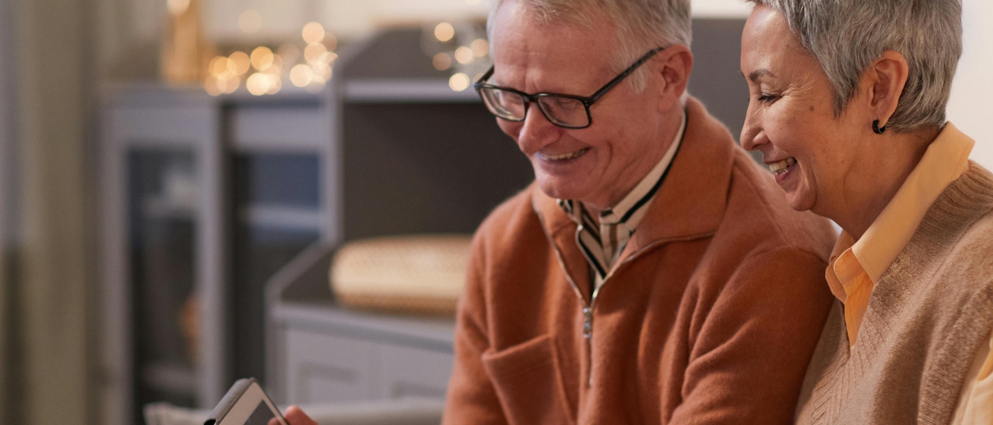 Two older people viewing an iPad.