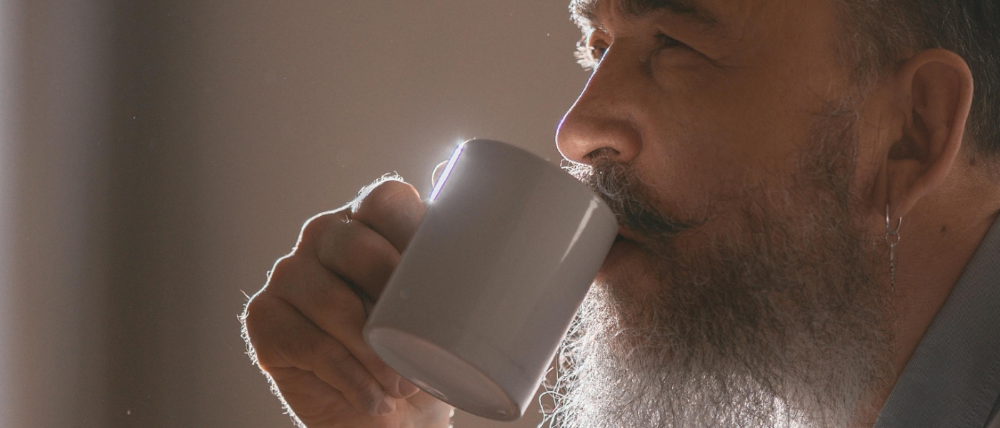 A man with a beard drinking coffee