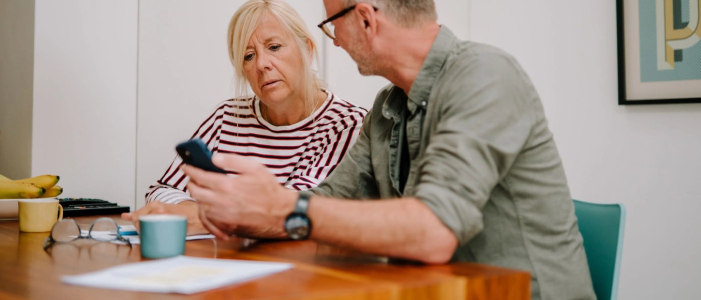 An older man and woman sit at a table talking.