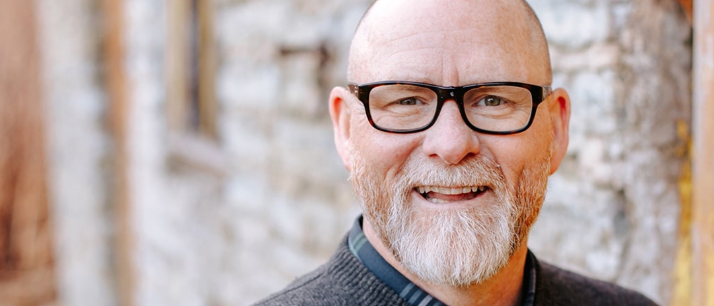 A smiling older man with glasses