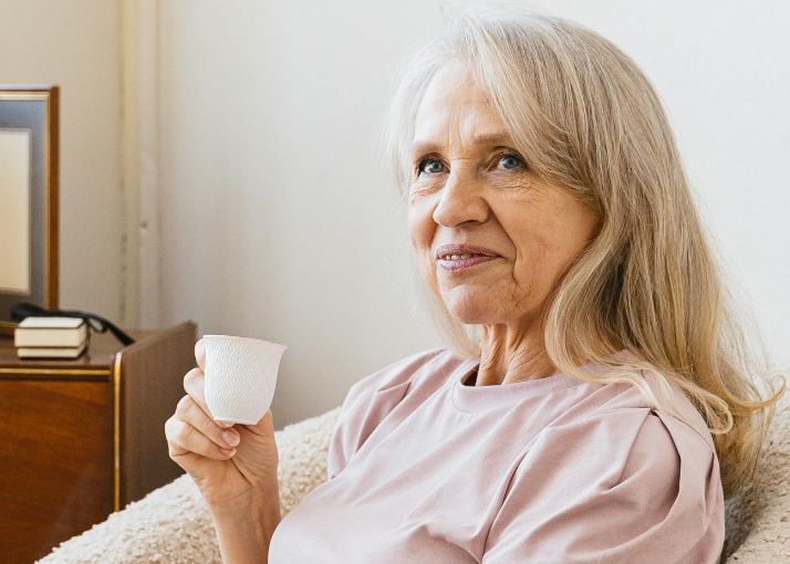 An older woman with a cup of tea.