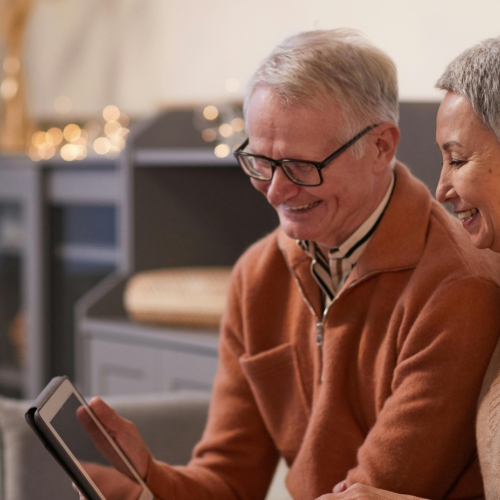 An older man and women view an ipad