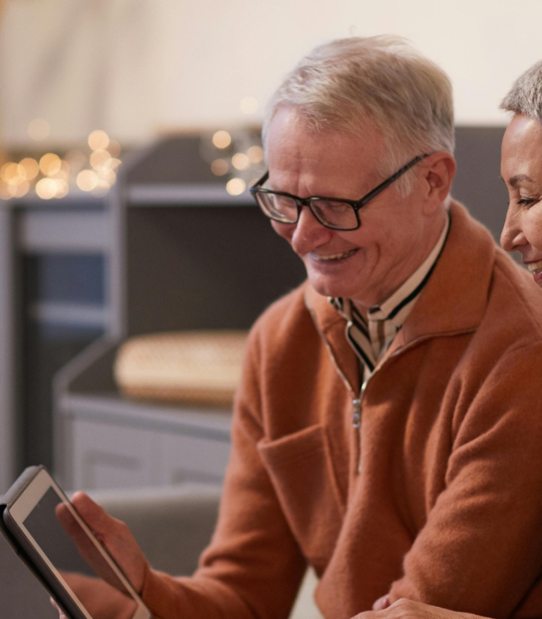 An older man and women view an ipad