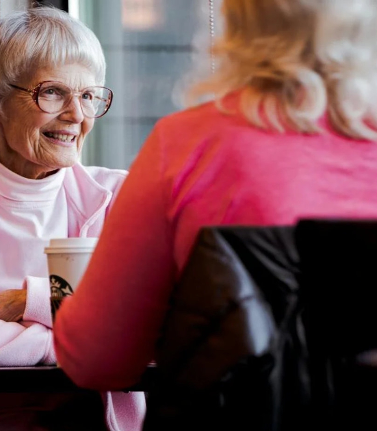 Two women sit at a restaurant table chatting.