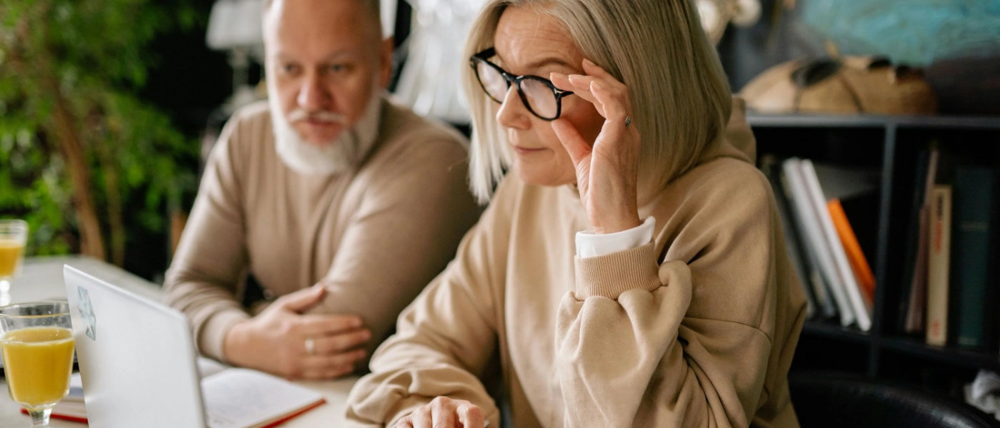 An older man and woman view a laptop computer