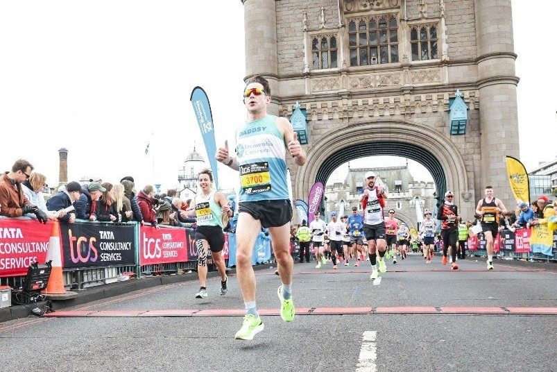 Dementia Concern runner running by Tower Bridge.